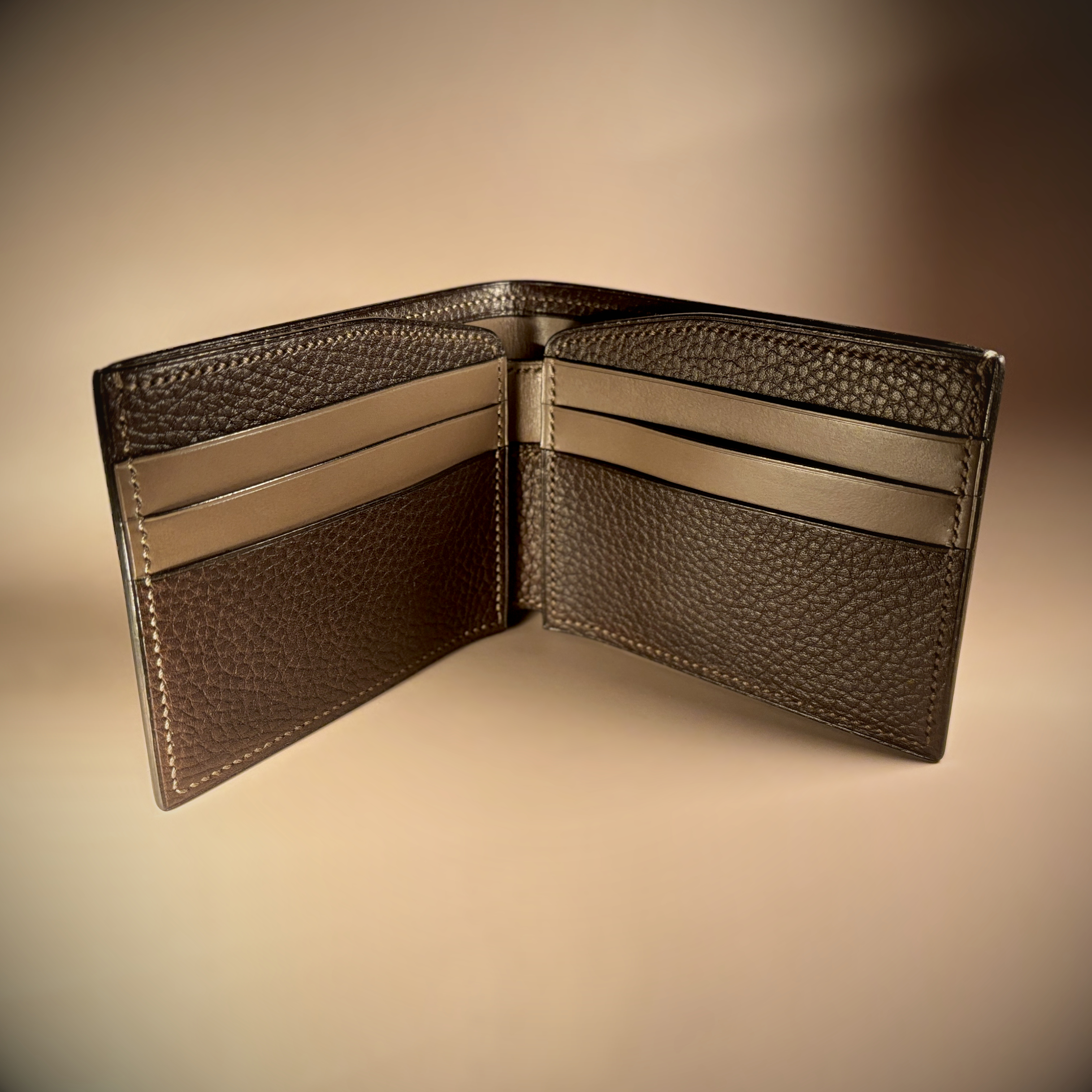 Unique handstitched textured dark brown shell and textured and smooth brown and taupe interior bifold wallet interior view