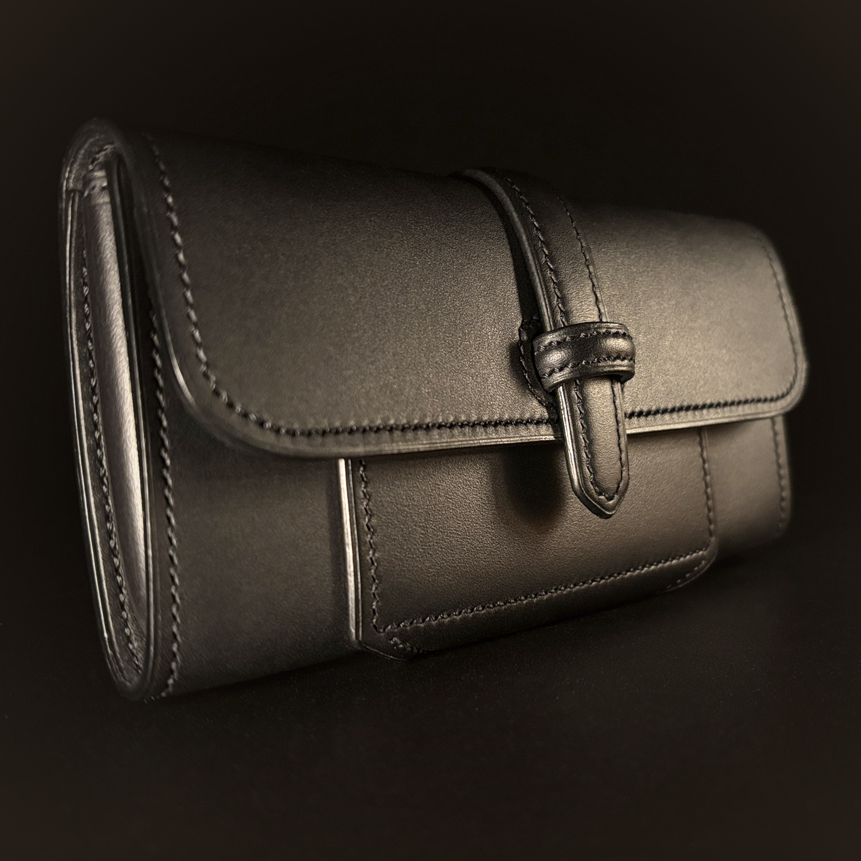 Luxury handstitched matte black clutch purse with unique tab closure view of front of closed purse