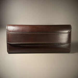 Unique handstitched tuck closure walnut shell and black and brown textured curved interior long wallet exterior font view