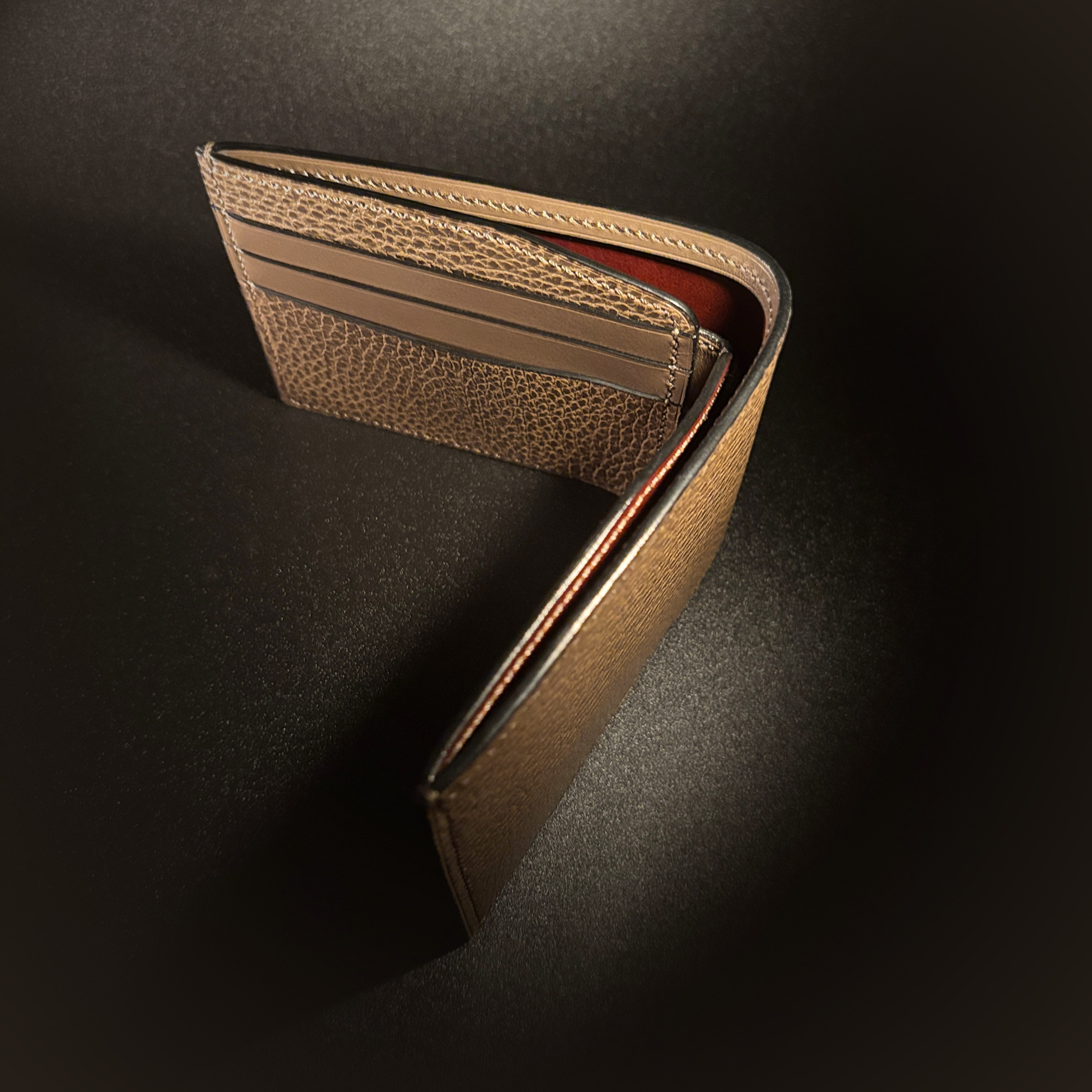 Unique handstitched textured taupe with red accent cash compartment bifold wallet top red accent view