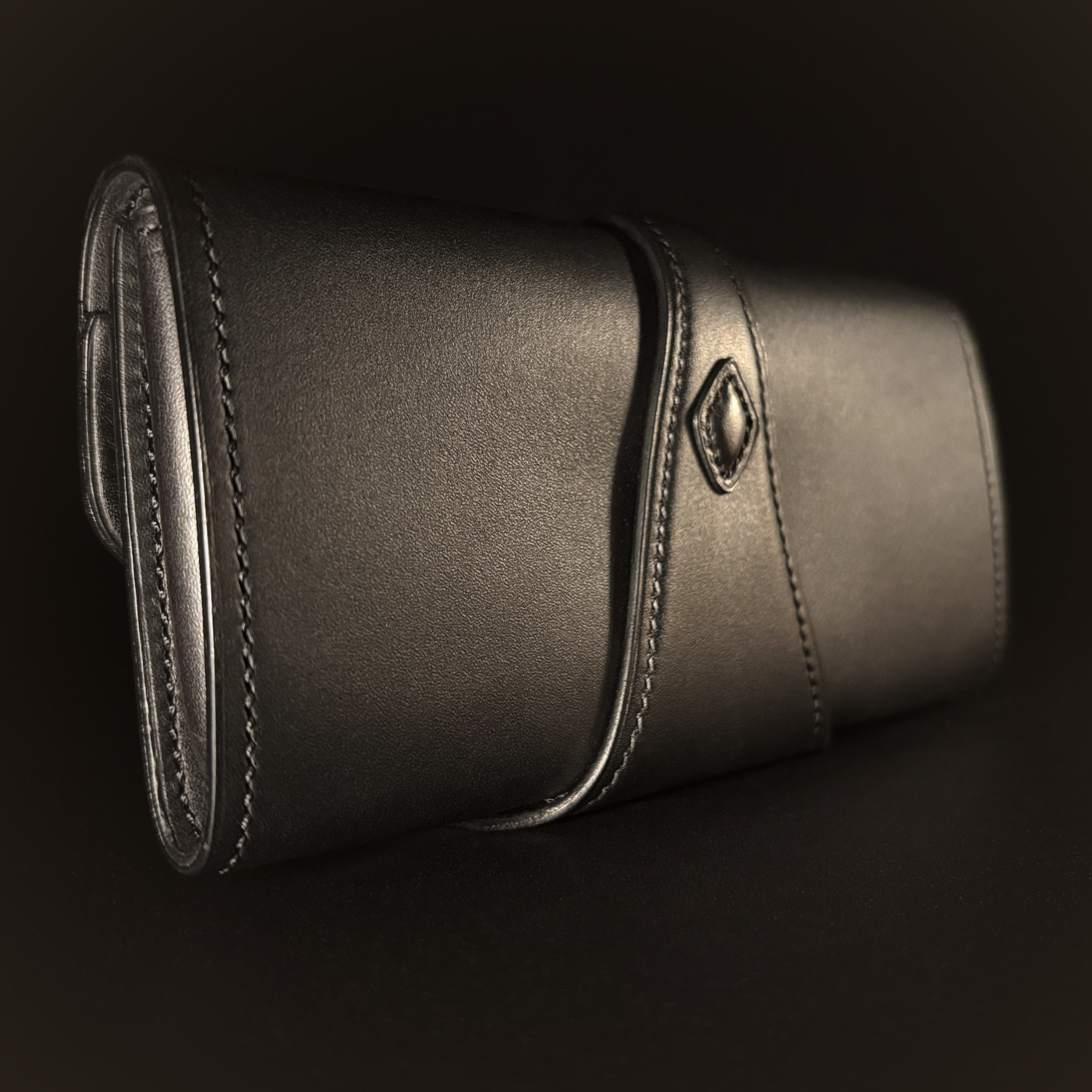 Luxury handstitched matte black clutch purse with unique tab closure view of back of closed purse