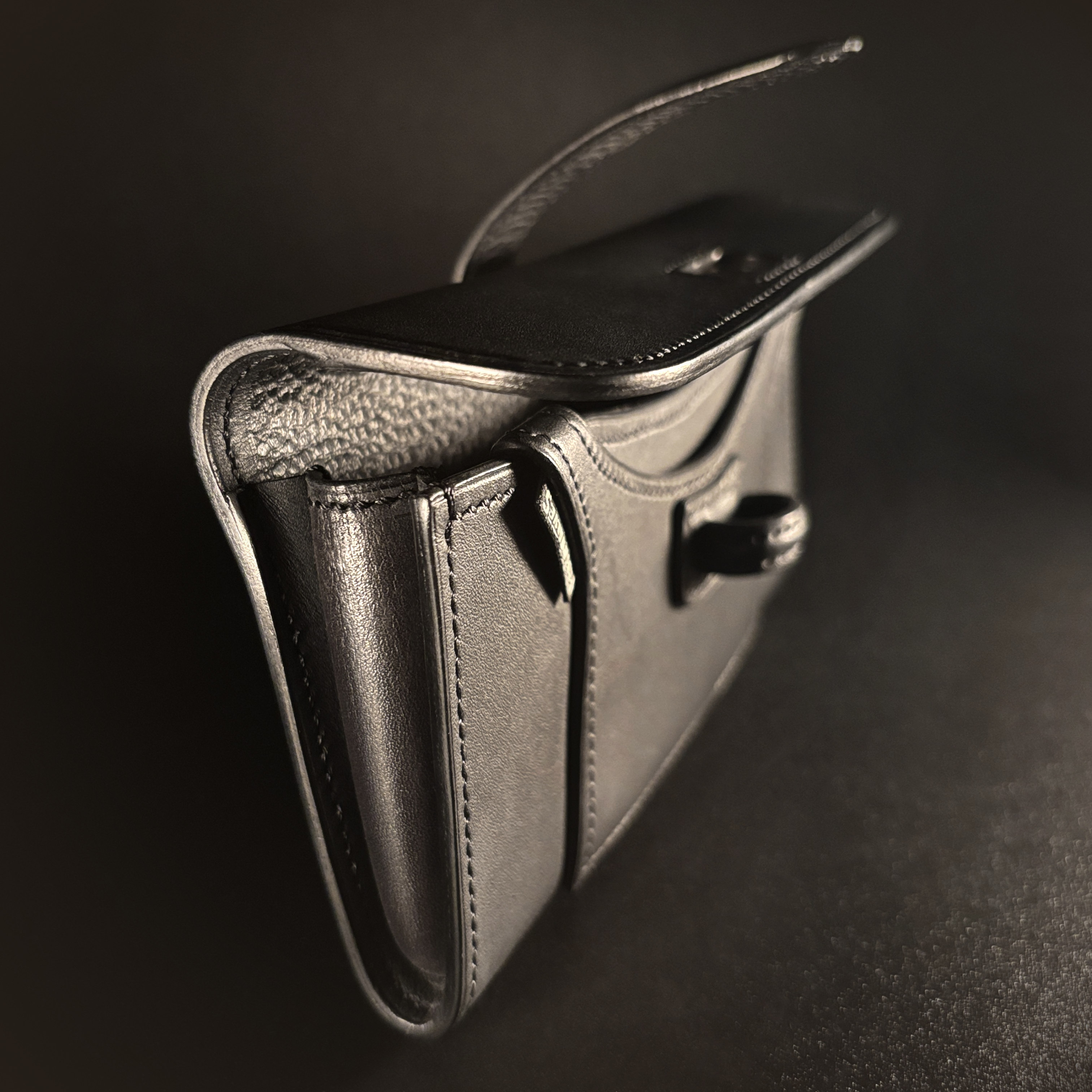 Luxury handstitched matte black clutch purse with unique tab closure view of side of opened purse