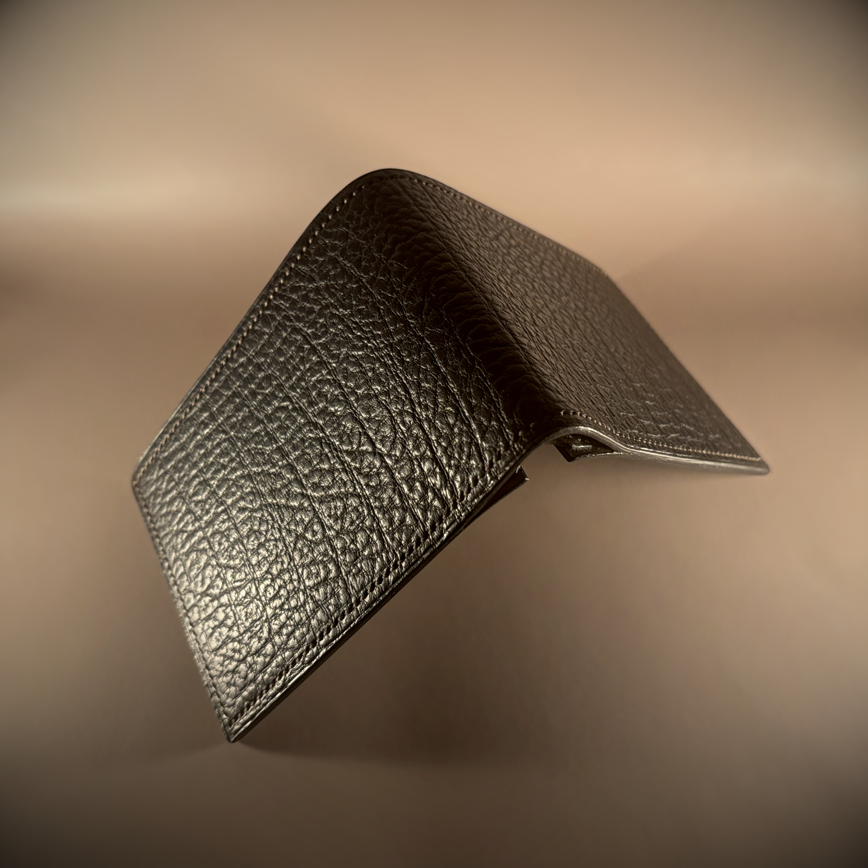 Unique handstitched textured dark brown shell and textured and smooth brown and taupe interior bifold wallet exterior shell view