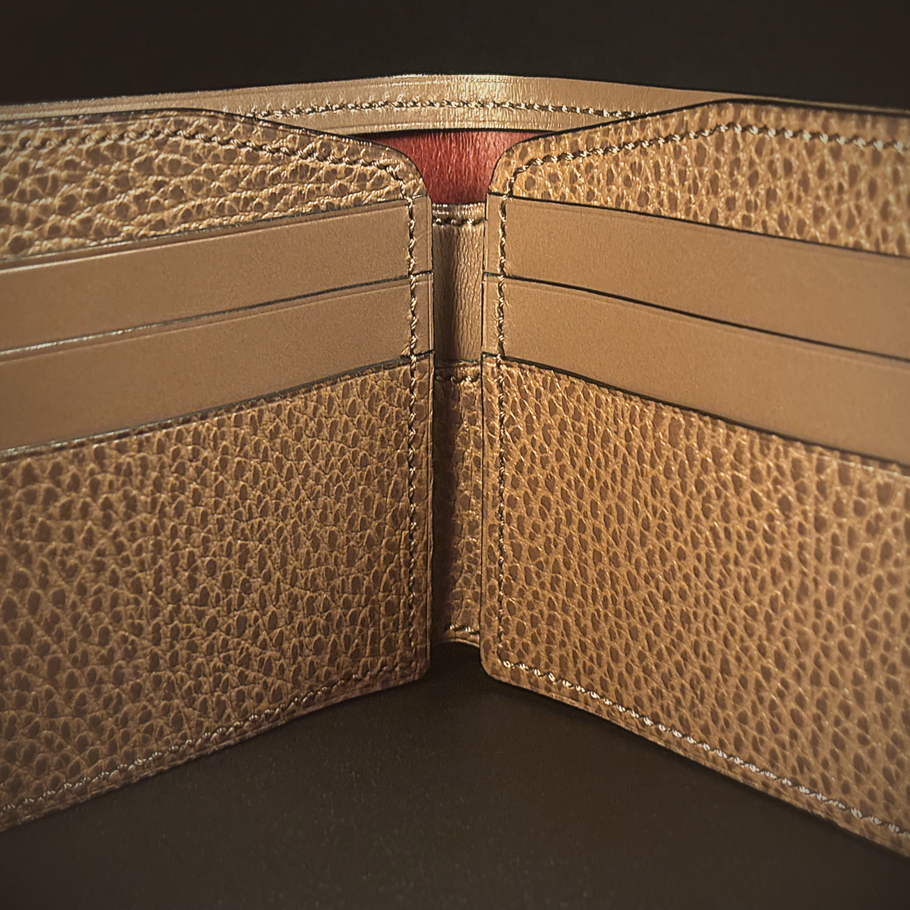 Unique handstitched textured taupe with red accent cash compartment bifold wallet interior detail view