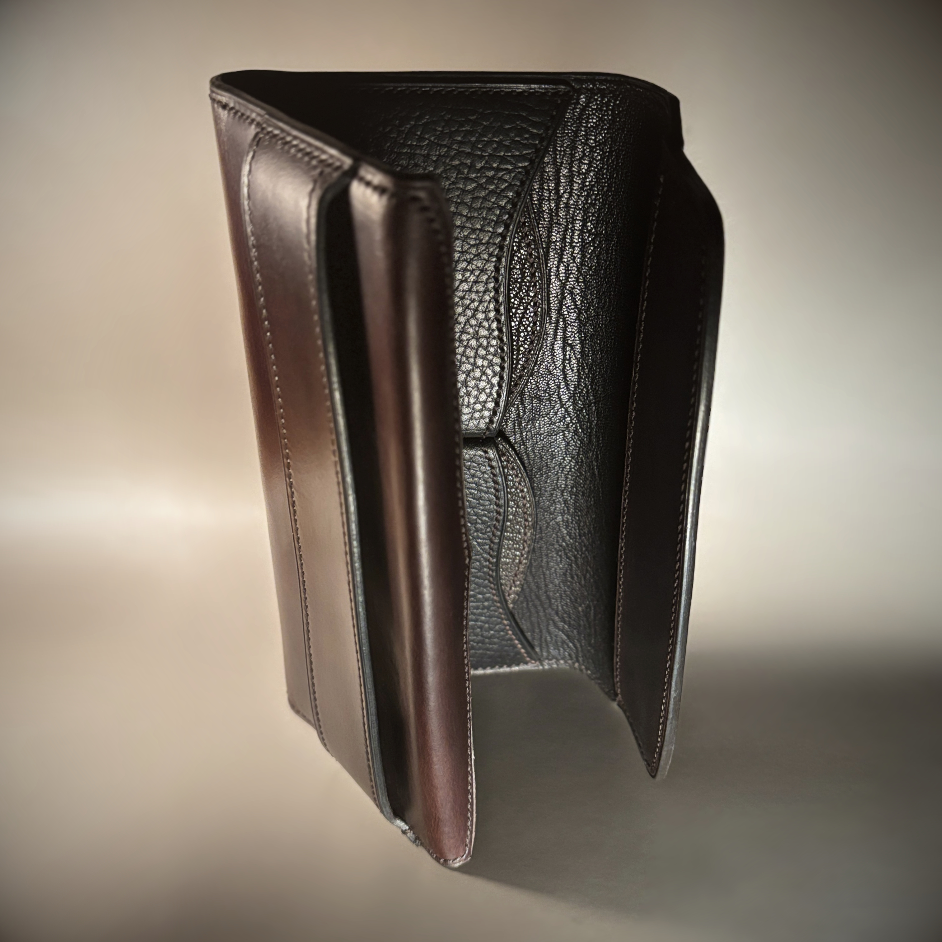 Unique handstitched tuck closure walnut shell and black and brown textured curved interior long wallet interior view