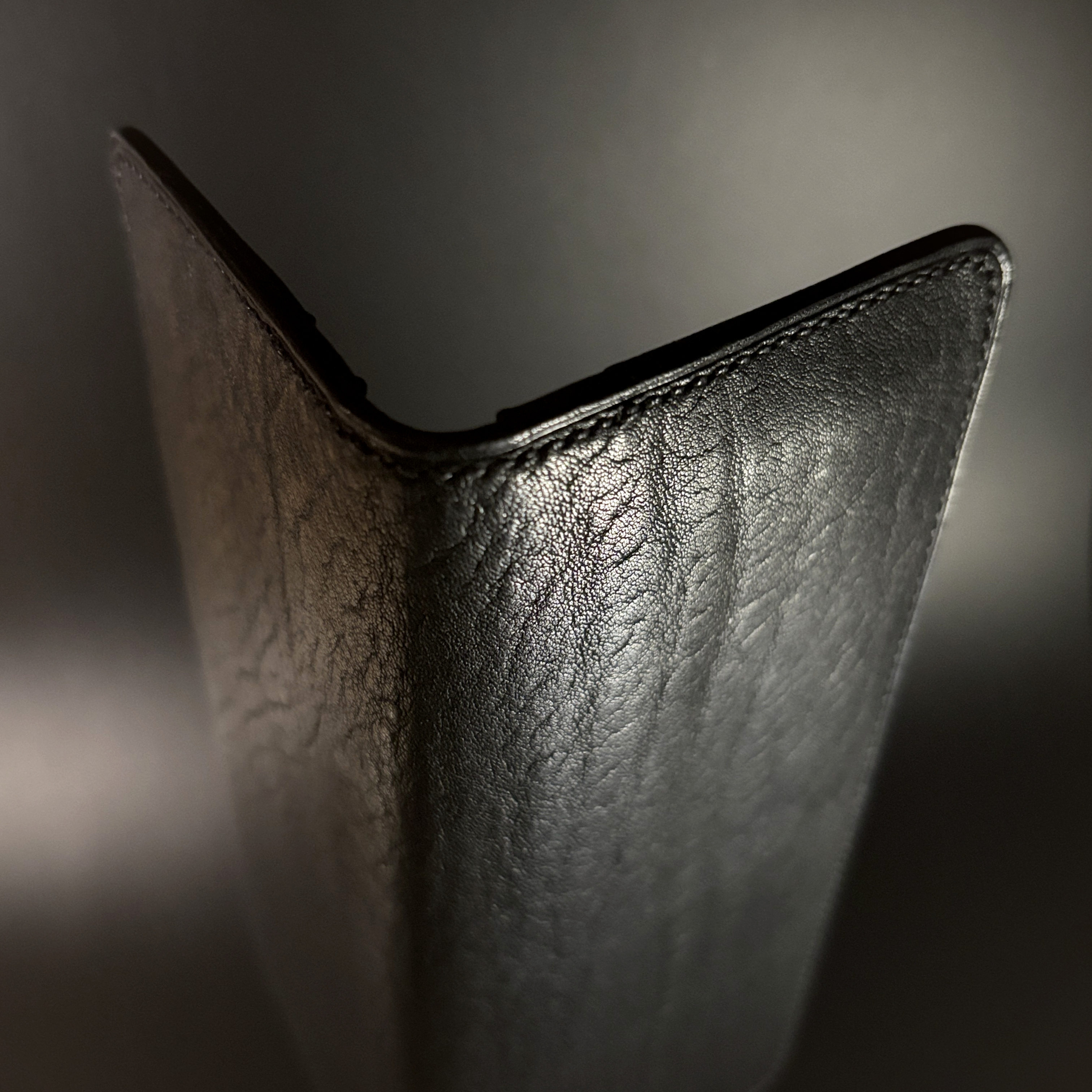 Unique hand-stitched all black cash and card long wallet exterior shell detailed view