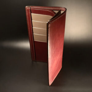 Unique hand-stitched oxblood shell and red and taupe interior cash and card long wallet side view