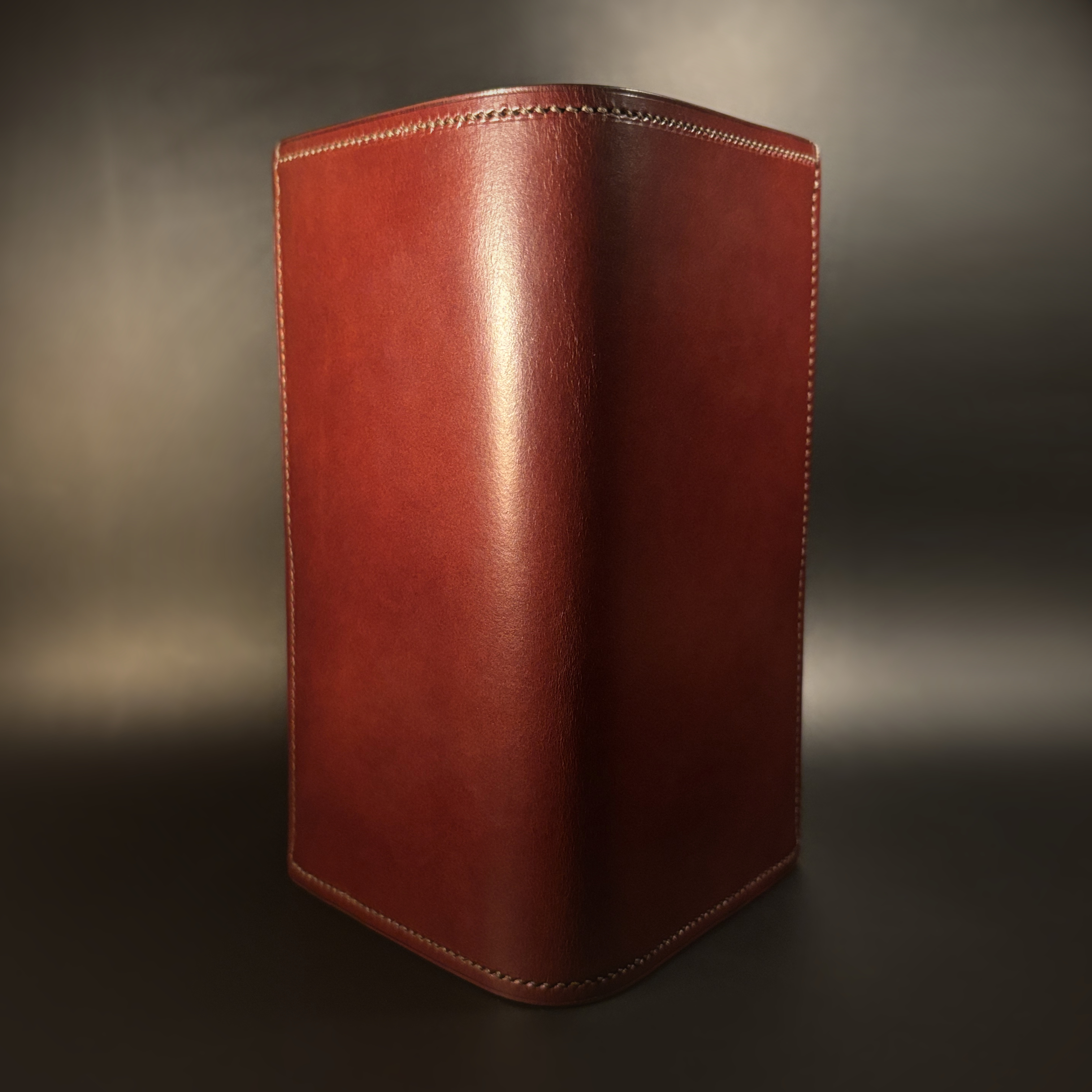 Unique hand-stitched oxblood shell and red and taupe interior cash and card long wallet exterior shell view