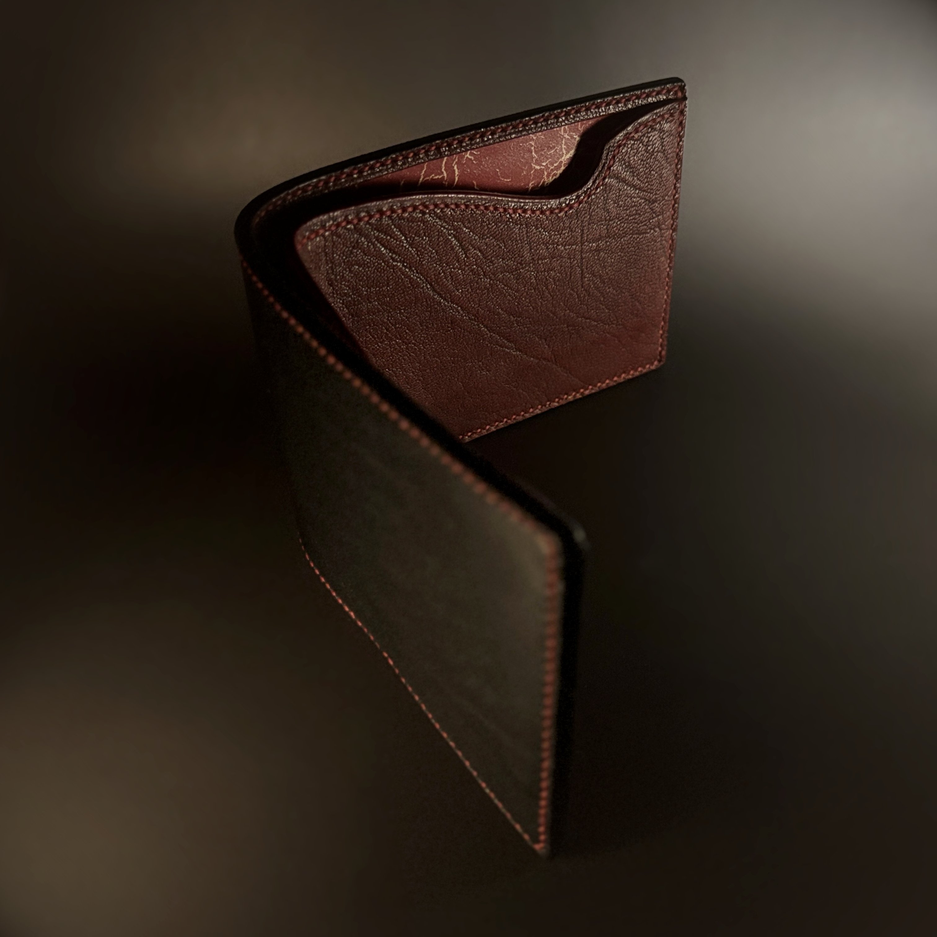 Unique hand-stitched black red and yellow-cracked faceless hidden credit card and cash bifold wallet side view