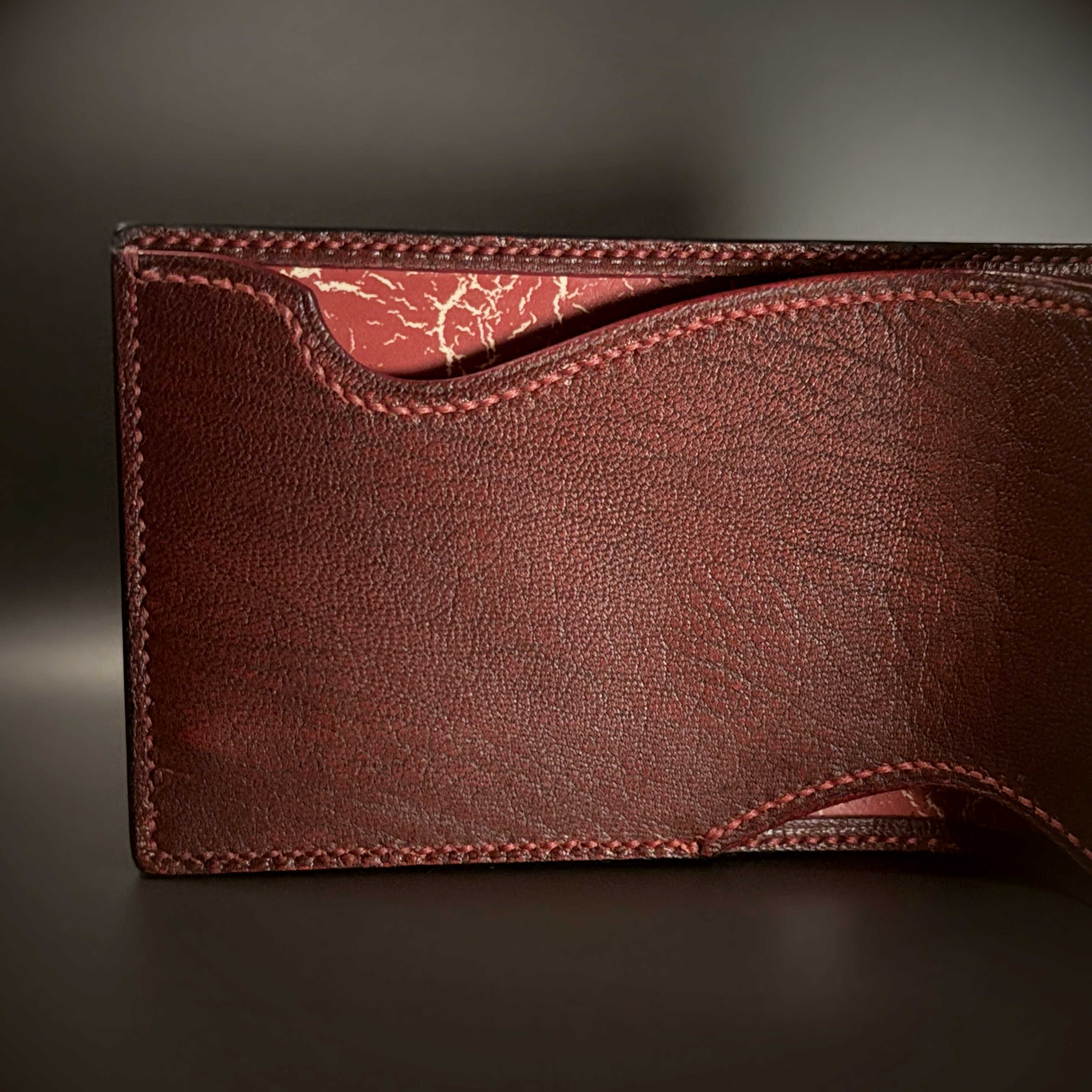 Unique hand-stitched black red and yellow-cracked faceless hidden credit card and cash bifold wallet interior detail view