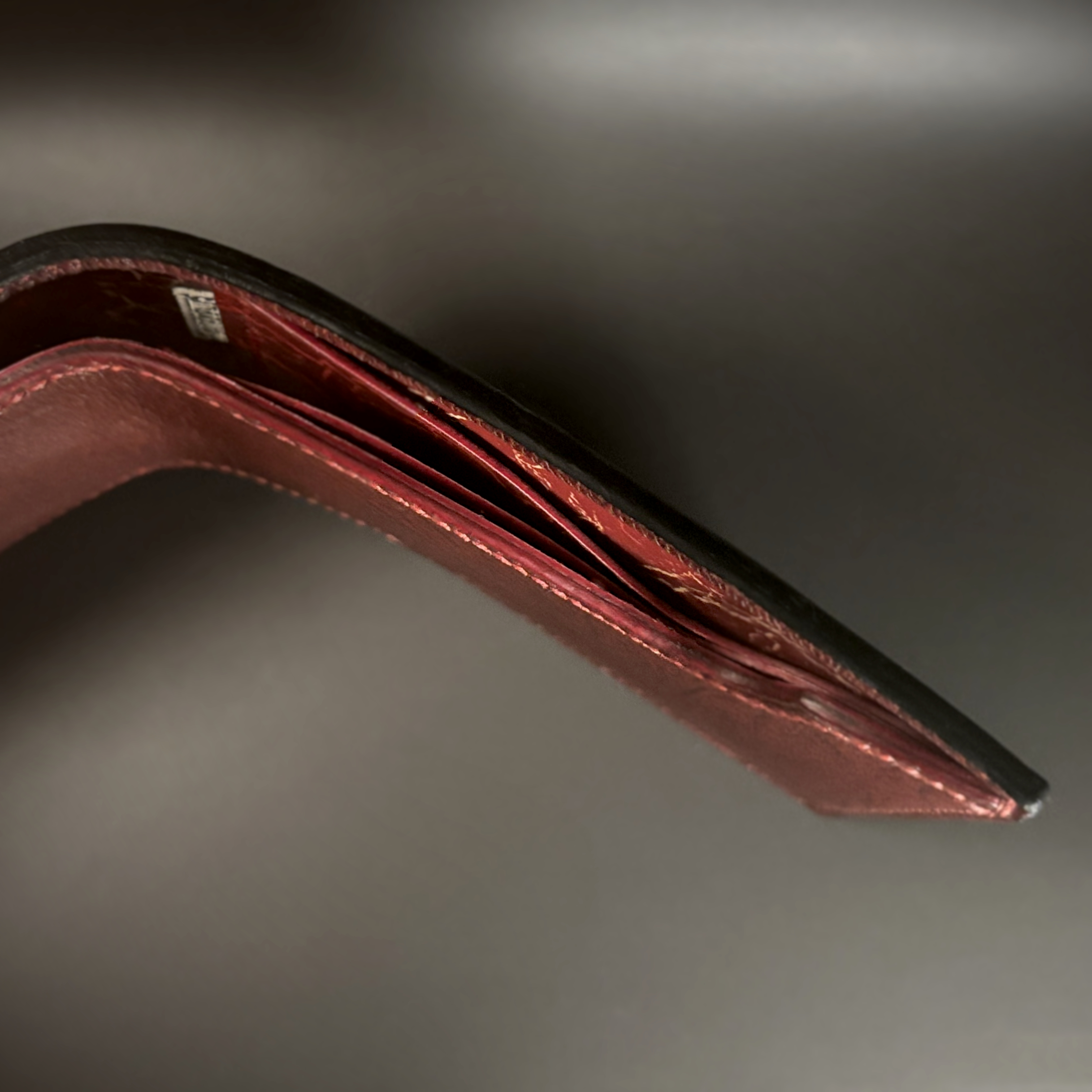 Unique hand-stitched black red and yellow-cracked faceless hidden credit card and cash bifold wallet top view