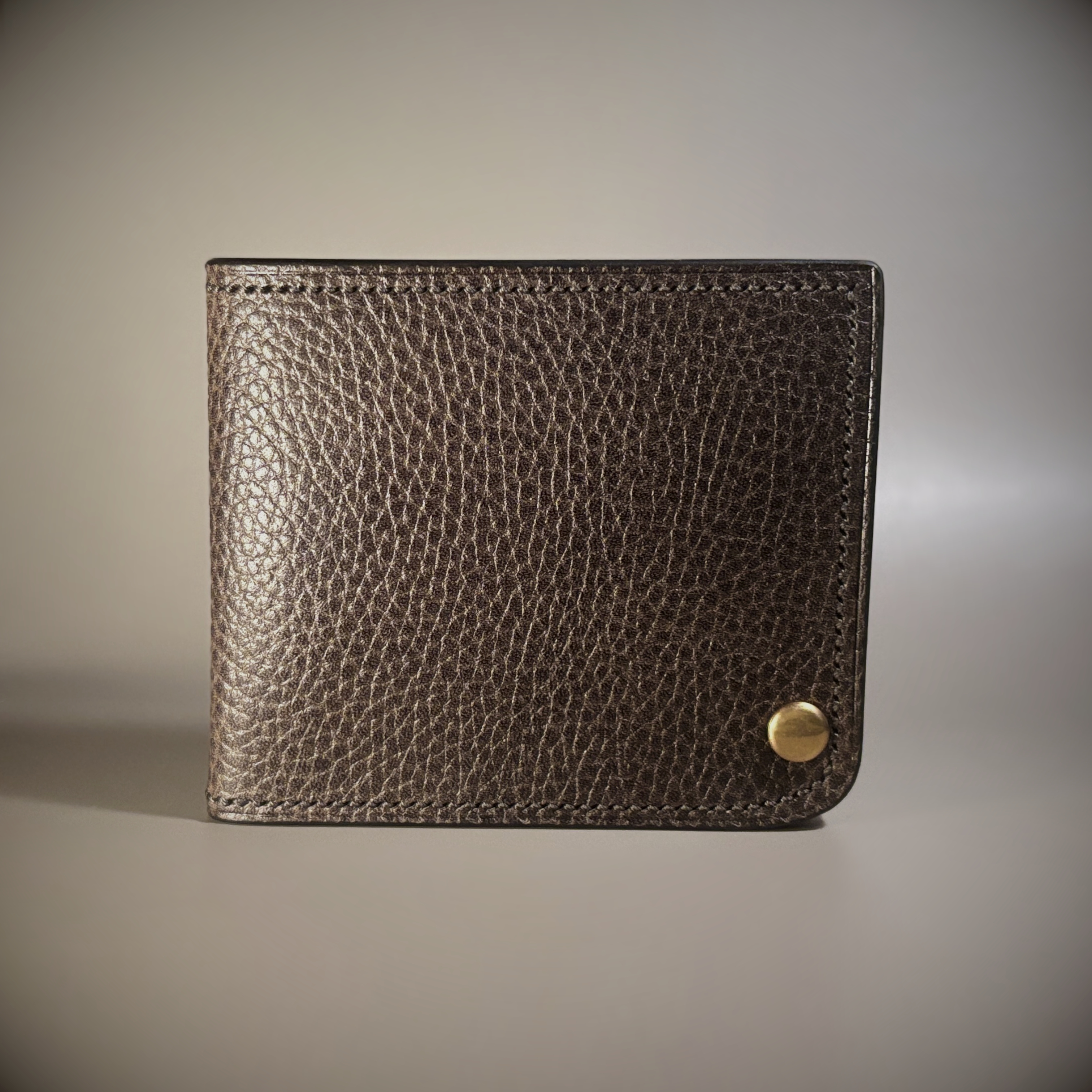 Unique hand-stitched brass hinged brown and black wallet exterior hinge closed view