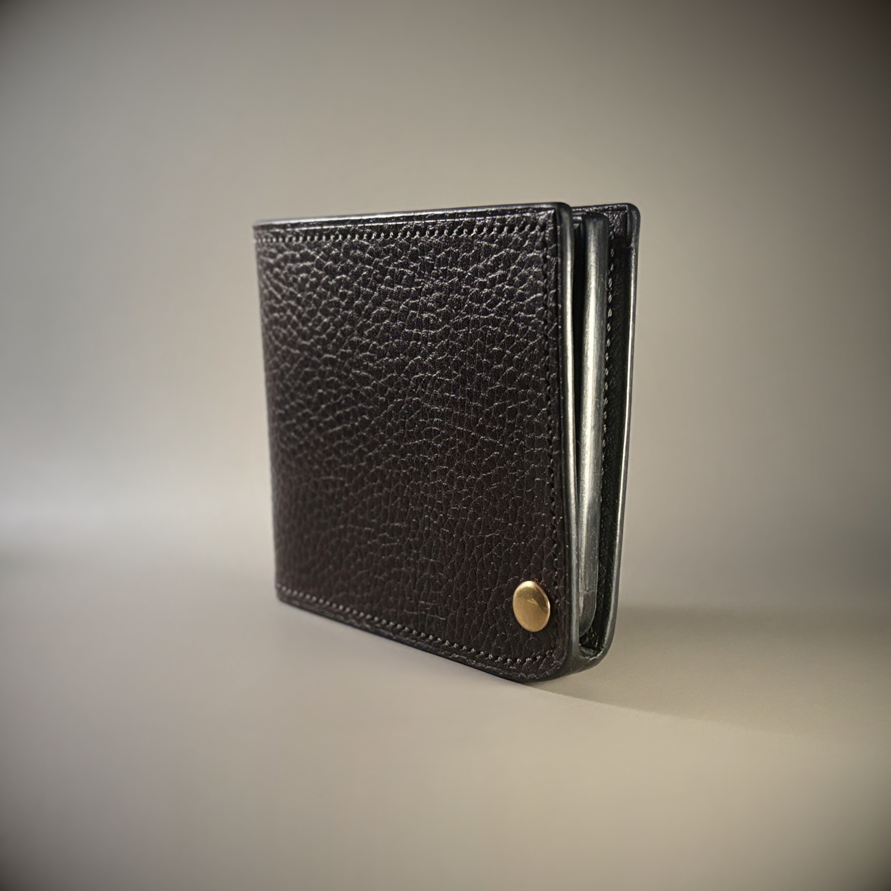 Unique hand-stitched brass hinged brown and black wallet exterior hinge closed side view