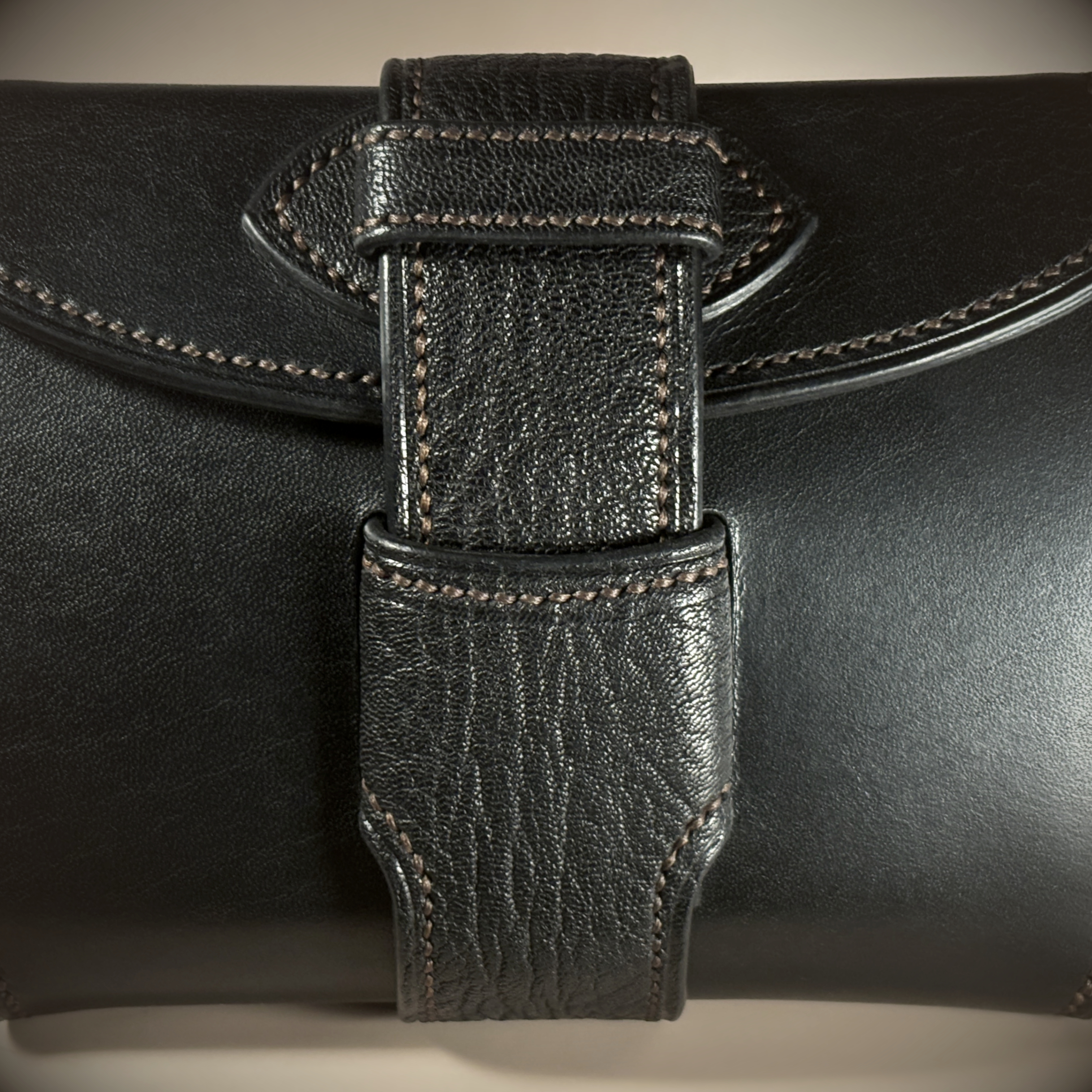 Unique handstitched black with red accent tuck closure purselette front closure detail view