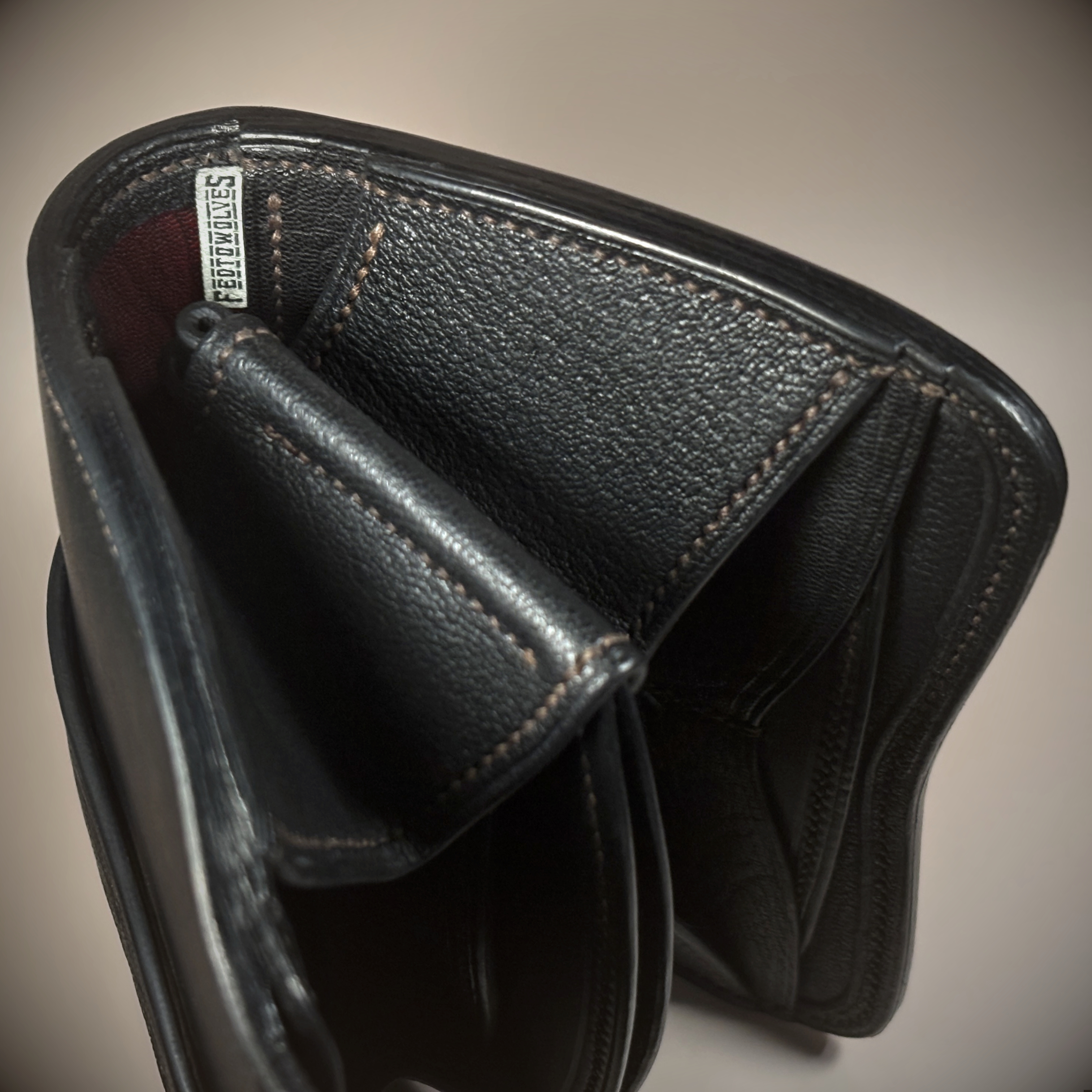 Unique handstitched black with red accent tuck closure purselette side and red accent detail view