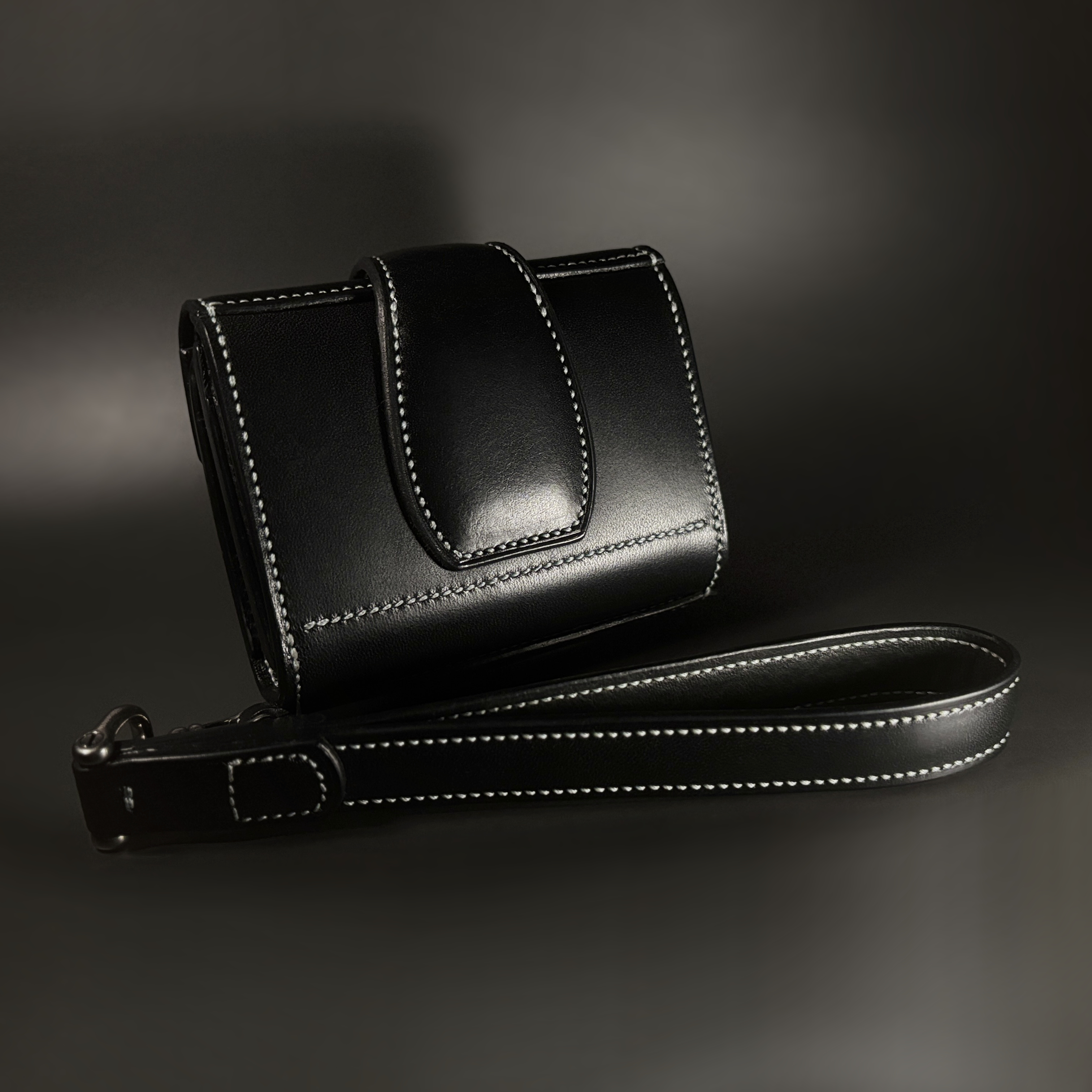 Unique handstitched black tuck closure wristlet strap purselette exterior shell rear view
